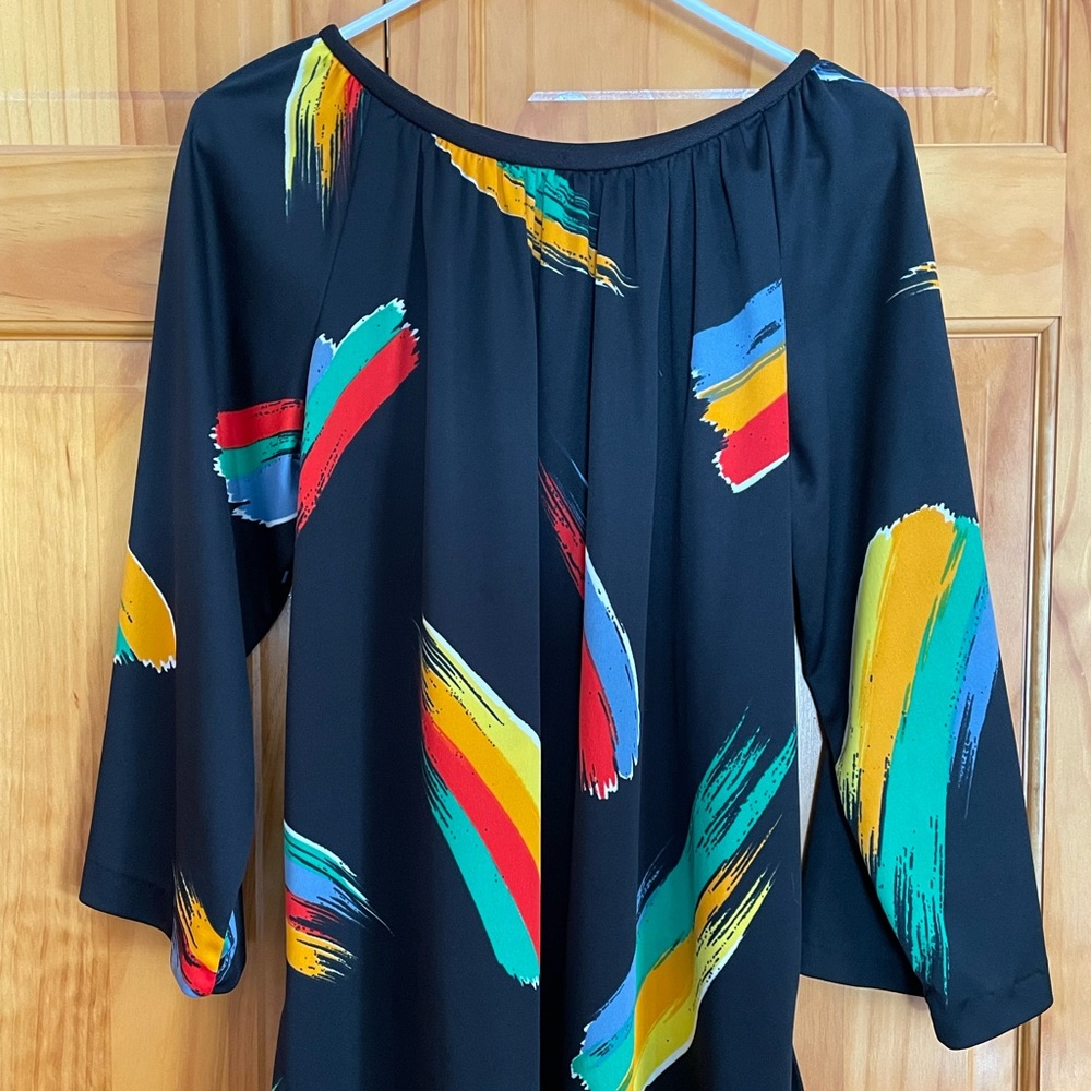 Black tunic is decorated by colorful Paintbrush swipes. Long sleeves.